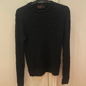 Svart kabelstickad tröja från Morris  - Fet kabelstickad tröja i merinoull från Morris . Tröjan är i storlek S men passar även XS. Skicket är 9/10 och inga defekter förekommer. Svarar alltid snabbt så skriv gärna om du undrar något!