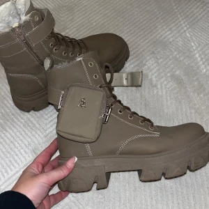 Steve Madden boots - Snygga bruna boots från Steve Madden med snörning och dragkedja. De har en praktisk ficka på sidan. Perfekta för höst och vinter.