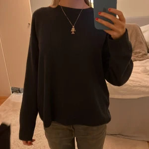 Mörkblå tröja med långa ärmar - Säljer en stilren mörkblå tröja med långa ärmar och ribbade muddar från zara. Perfekt för en avslappnad look. Tröjan har en normal passform och är gjord i ett mjukt material.