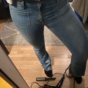 Blå bootcut jeans - Säljer ett par blå bootcut jeans i bra skick. De har en klassisk femficksdesign och är tillverkade i jeansmaterial. Finns en del effekter där av priset, kom gärna privat för bild