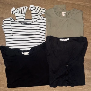 Fyra toppar i olika stilar - Säljer ett set med fyra olika toppar. En randig svartvit med volang ärm. En grön vanlig långärmad. En svart offshoulder och en svart långärmad finstickad med knappar 