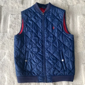 Blå quiltad väst från Ralph Lauren - Säljer en snygg blå quiltad väst från Ralph Lauren. Jack är i topp skick och passar dig som är runt 170 lång 