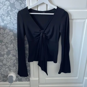Svart långärmad topp med knyt - Snygg svart långärmad topp från Gina Tricot med knyt framtill.