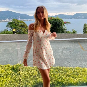 Vit blommig offshoulder klänning från Nelly - Charmig vit klänning med blommigt mönster och offshoulder-design. Använd ett fåtal gånger! 