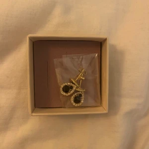 Guldiga oanvända Lily and Rose örhängen i guld - Guldiga oanvända Lily and rose örhängen. Perfekt som present till någon pga plomberingen. 