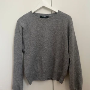 Grå kashmirtröja från Lisa Yang - Grå kashmirtröja från Lisa Yang, strl 1,  Tröjan har en rund hals och långa ballongärmar, den är i nyskick och använd väldigt fåtal gånger, inga tecken på användning. Säljs inte längre men är köpt för 4400kr🤍