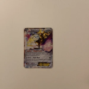 Pokémonkort Aegislash - Säljer ett Pokémonkort med Aegislash. Kortet har en färgglad design med Aegislash i fokus och har 170 HP. Perfekt för samlare eller Pokémon-entusiaster!