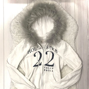 hollister fur zip up - handsydd därav FAST pris! nackdelen är att den är lite skrynklig men det går såklart att fixa med strykjärn. texten är mörkblå, och då koftan är en XS sitter den lite kroppsformat och når höfterna. 🐾handtvätt med ljummet vatten då torktumlare + tvättmaskin förstör pälsen. <3