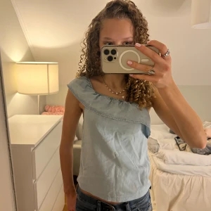Ljusblå topp med volang - Säljer denna söta jeans inspirerade toppen som går att använda off shoulder och på ena axeln🥰💕mycket fint skick😍