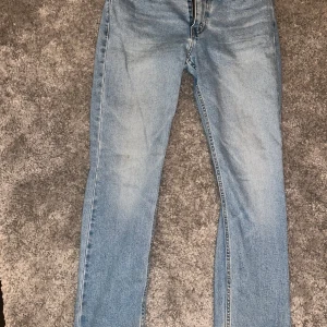 Blå jeans från Levi's - Säljer ett par klassiska blå Levi's jeans med rak passform. De har en dragkedja och knapp framtill samt fem fickor. Perfekta för en avslappnad stil.
