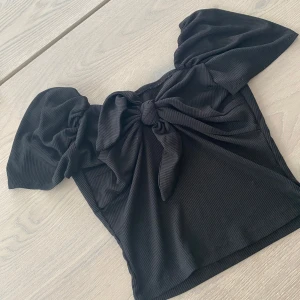 Svart ribbad knytblus - Söt svart ribbad blus med knytning framtill. Knappt använd💗