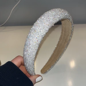 Glittrigt diadem i silver - Snyggt diadem täckt av glittrande paljetter i silver. Perfekt för att ge en extra touch till din outfit. Diademet har en bekväm passform och är lätt att bära hela dagen. 