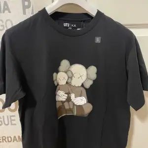 Kaws x Uniqlo Short Sleeve Artbook Prislappen finns kvar Storlek M