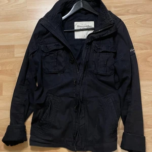 Marinblå feildjacka - Säljer en snygg marinblå field jacka från Abercrombie & Fitch i storlek L. Perfekt för höst och vinter. Skriv för fler bilder eller andra funderingar. 