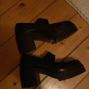 Mary Janes ❤️36-37 - Säljer ett par svarta Mary Janes från Jonak i mycket bra skick. De har en rejäl klack och grov sula som ger en cool look. Perfekta för höst och vinter, och funkar både till vardags och fest. Skorna är i skinn och har en stilren design med en liten rem över foten. Köpt för 1500 (använd några få gånger) säljer för 950 ❤️