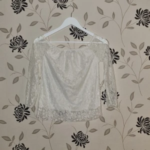 Vit spetsblus från Finejo, Strl: M/38/40 - Säljer en fin vit spetsblus från Finejo i storlek M. Blusen har trekvartsärmar och en offshoulder-design som ger en romantisk look. Perfekt för vår och sommar, både till vardags och fest. Materialet är mjukt och bekvämt, vilket gör den lätt att bära hela dagen. 🌸