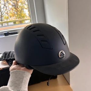 Back on Track ridhjälm - Marinblå back on track ridhjälm. Den är i superfint skick och används sparsamt av min lillasyster under 1 år 1gång/veckan på ridskola. Aldrig avramlad i. Nyrpris ca 2000kr säljer för 600kr. 