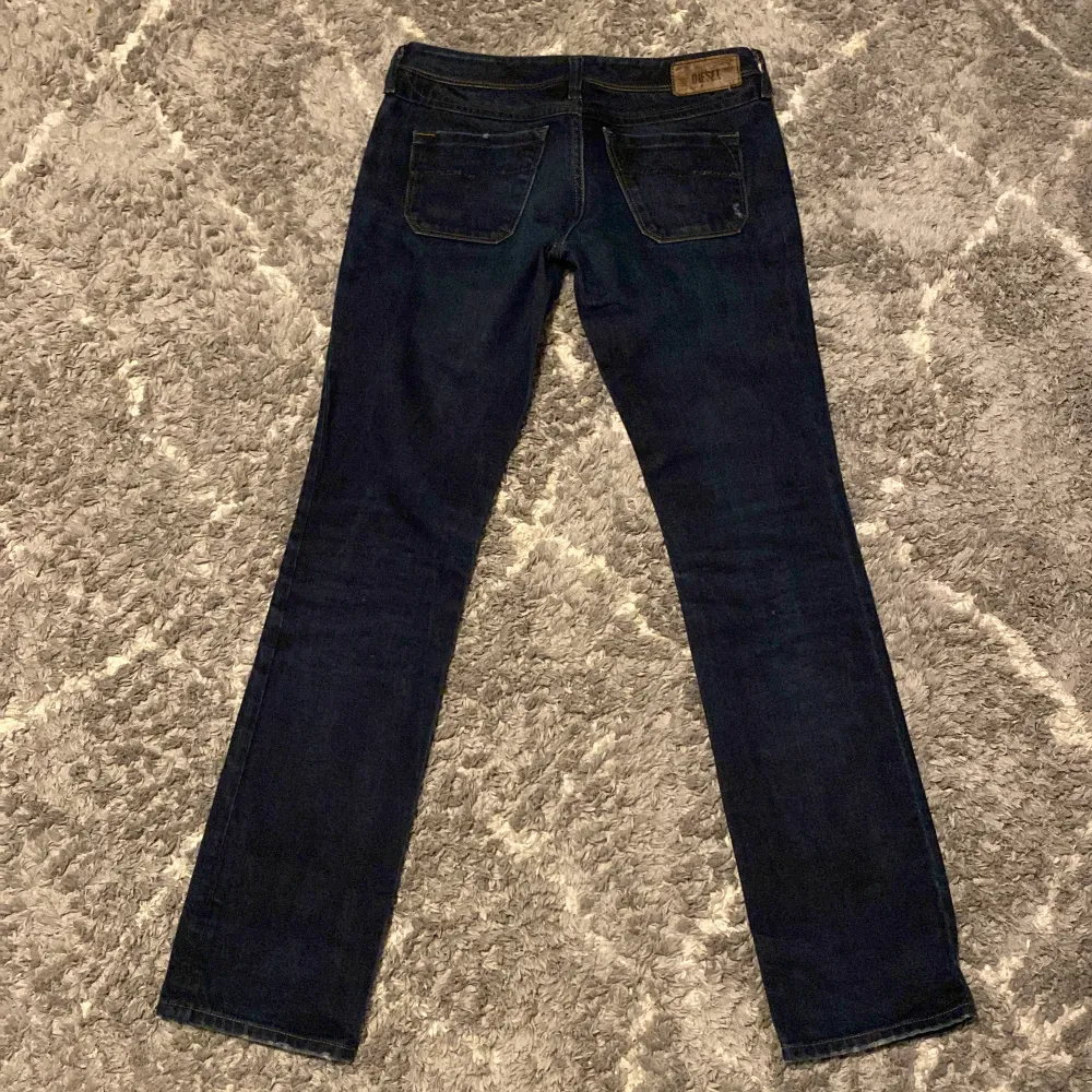 Ett par snygga dieseljeans i bra skick. De är straight leg och Low Rise. Midjemåttet är 39 cm rakt över och innerbenslängden är 84 cm. Det är i en väldigt mörkblå färg . Jeans & Byxor.