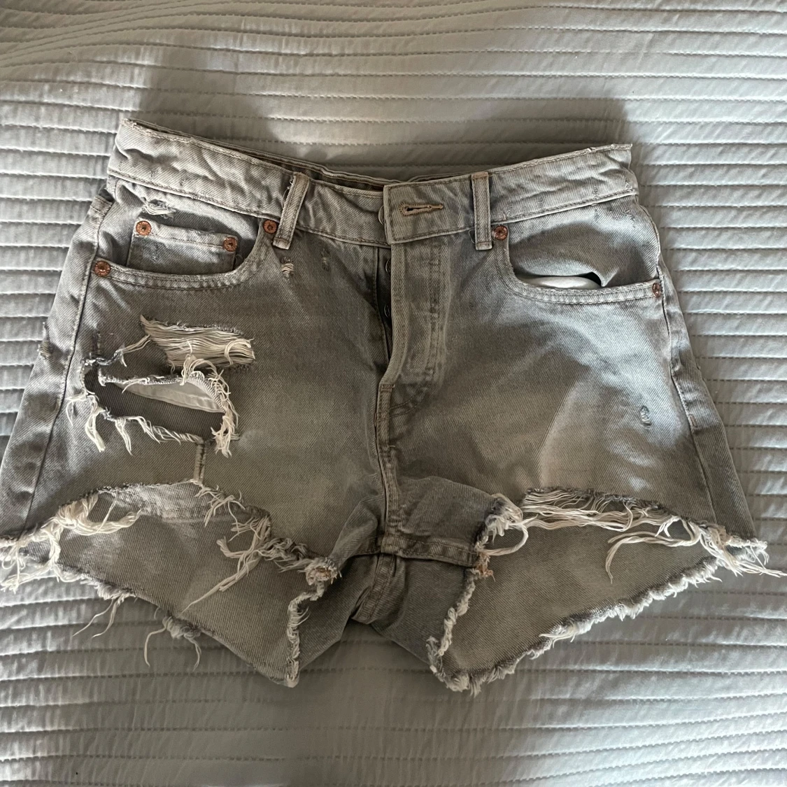 Grå jeansshorts med slitningar