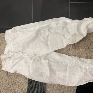 Vita linnebyxor - Säljer ett par vita linnebyxor i loose fit. Perfekta för sommaren med sin lätta och luftiga känsla. Byxorna har en bekväm resår i midjan och är i mycket bra skick. Perfekta för en avslappnad dag på stranden eller en somrig utflykt. 🏖️