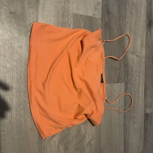 Orange linnetopp från Gina Tricot - Säljer en snygg orange linnetopp från Gina Tricot i storlek S. Perfekt för sommardagar med sina tunna axelband och lätta material. Toppen är i bra skick och passar utmärkt till både jeans och kjol. 🌞