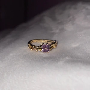 Guldfärgad ring med lila blomma - Fin guldfärgad ring med lila stenar och bladdetaljer 🩶~18 mm och justerbar 🩶Kolla gärna resten av mina annonser för samfrakt. 
