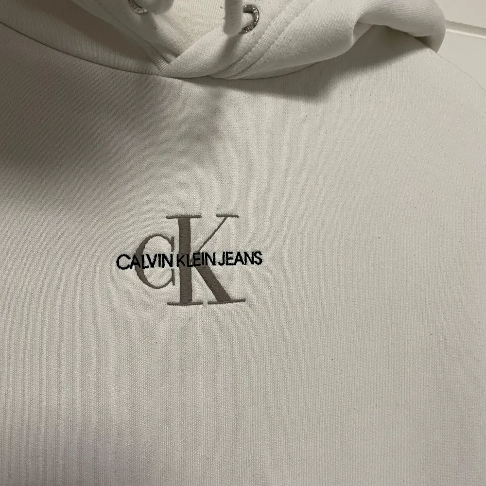 Säljer en sparsamt använd vit hoodie från Calvin Klein i storlek S. Den har en klassisk, stilren design med broderad logga på bröstet med bokstäverna CK i beige och en bekväm känguruficka. Bara att höra av dig vid frågor!😊. Tröjor & Koftor.