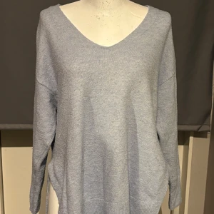 Ljusblå stickad tröja från H&M - Mysig ljusblå stickad tröja från H&M i storlek M. Perfekt för kyliga dagar med sin bekväma passform och v-ringade hals. Tröjan har långa ärmar och är superenkel att matcha med jeans eller kjol. Ett måste i garderoben för höst och vinter! 💙