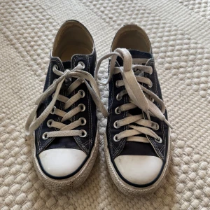 Låga Converse sneakers - Säljer ett par klassiska blå/grå låga Converse sneakers i bra skick. Perfekta för både vardag och fest! Passar till nästan allt i garderoben. 