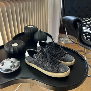 Saint Laurent star sneakers - Saint Laurent ”star sneakers” i svart/grått jeans material. Har dessvärre inte kvar tillbehören, men självklart äkta! Mycket bra skick! Obs, sulan ska vara lite gulaktig. Nypris ca 7 000kr. 