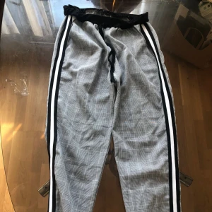 En par kostymbyxor - Ett par grå randiga kostymbyxor