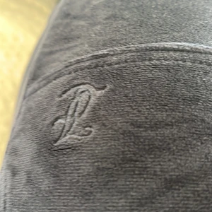 Svarta mjukisbyxor från Juicy Couture - Säljer ett par svarta mjukisbyxor från Juicy Couture. De är superbekväma och perfekta för en chill dag hemma eller en avslappnad utflykt. Byxorna har en broderad logga och är gjorda i ett mjukt material som känns skönt mot huden.