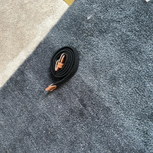 Svart bälte med bruna detaljer - Säljer ett snyggt svart bälte med bruna läderdetaljer. Perfekt för att ge en stilren touch till din outfit. Bältet är i nyskick och passar både till vardag och fest. Justerbar längd för bästa passform.