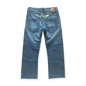H&M Relaxed blå jeans med tryck - Snygga jeans med en cool design. Storlek 170 men passar som 30/30.  I fint skick.   Ifall mått önskas var god kontakta mig!
