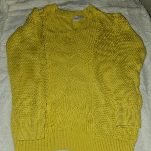 Gul stickad tröja från Saint Tropez - Nytt!  Säljer en superfin gul stickad tröja från Saint Tropez. Den har en snygg v-ringning och ett detaljerat stickmönster som ger den en unik look. Perfekt för att lysa upp höst- och vintergarderoben! Nypris 699 kr