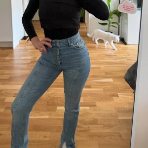 Ljusa jeans med hög midja och knappar - Säljer ett par snygga ljusblå jeans med hög midja och coola knappar framtill. De har en straight passform som ger en klassisk look. Perfekta för både vardag och fest! 🦋
