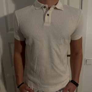 Vit pikétröja från H&M i nyskick - Säljer en stilren vit pikétröja från H&M i storlek S. Tröjan har en slim fit passform och är gjord i ett bekvämt bomullsmaterial. Tröjan är i utmärkt skick! Storlek S och passar som liten M. Modellen är 182 cm och väger 75 kg. Pris går att diskuteras!