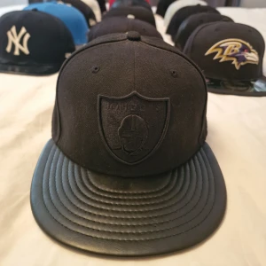 New Era Oakland Raiders Black on Black 59fifty - New Era Oakland Raiders Black on Black 59Fifty. Svart Polyester Crown & Svart läder Snapback.  Storlek: 7 (55.8cm). Sparsamt Använd!