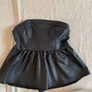 HM slutsåld peplumtopp - Säljer världens snyggaste peplumtopp. Den är från HM jag tror att den inte säljs mer och den är även slutsåld. Säljer för att den inte har kommit till användning, den är aldrig använd och har lappen kvar. Det är typ ett skinnsmaterial,passar till all