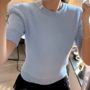 Ljusblå tröja med glittriga detaljer - Säljer en fin stickad t-shirt i supermjukt material, med glittriga knappar vid axeln och ärmsluten. Perfekt för både vardag och fest. Den är i storlek L, men passar mig som vanligtvis bär xs/s🩵I princip nyskick då den ej kommit till användning 