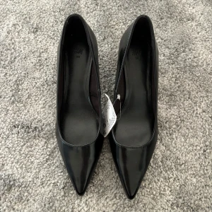 Klackskor - Svarta oanvända klackskor från H&M i storlek 38. Prislapp kvar!