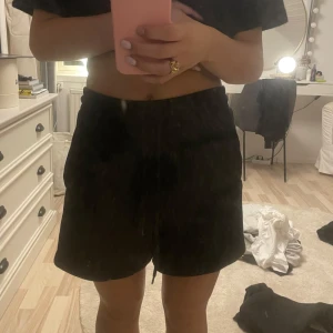 Svarta shorts från NA-KD - Säljer ett par svarta shorts från NA-KD i storlek XS. De är superbekväma med en elastisk midja, dom är ganska långa och i större storlek 🥰 