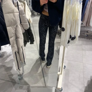 Grå leopardmönstrade byxor - Säljer ett par grå leopardmönstrade byxor som är supertrendiga och bekväma. Byxorna är i bra skick och har en snygg design som verkligen sticker ut. Passar mig perfekt som är en xs/s och 174cm, de är alltså långa💕💕