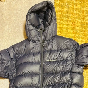 Peak performance dunjacka - Den klassiska peak dunjackan i mörkblått. Skick 9/10, enda defekten syns på bild nr 3 och är kardborrebandet på ena ärmen.  Kostar 4k ny  Kom med förslag på byten om du vill