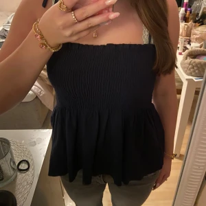 Svart axelbandslös topp - Säljer en fin mörkblå topp med. Endast testad och i nyskick!💕