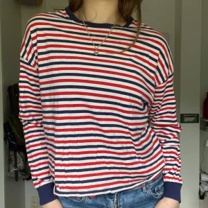 Randig långärmad tröja  - Randig tröja från Monki i rött vitt och marinblått, marinblå halsringning och muddar