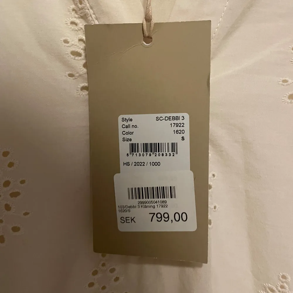 Säljer en söt beige klänning från Soyaconcept med korta ärmar och v-ringning. Klänningen har ett fint broderat mönster, ny med prislapp. Mekot.