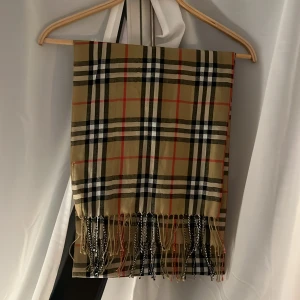 Burberry scarf/halsduk - Fått av farföräldrarna. Saknar lapp, därför säljs för mindre. Väldigt skön och inga hål. Skriv vid vilken fråga som helst