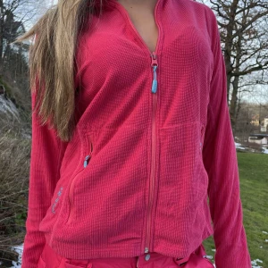 Rosa fleecejacka från Bergans - Säljer en snygg rosa fleecejacka från Bergans med dragkedja och praktiska fickor. Perfekt för sportlovet när man går på after ski, går att kombineras med byxorna i samma färg!! 