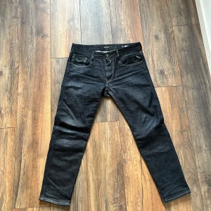 Svarta jeansbyxor från Replay - Snygga svarta jeansbyxor från Replay i modellen Anbass. De har en klassisk femficksdesign och en bekväm passform. Perfekta för en stilren look.                       W31 L32